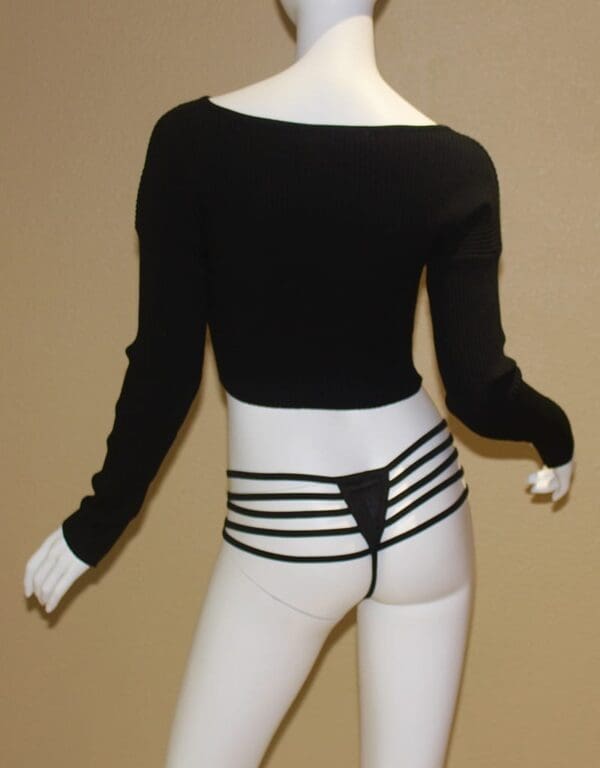 A mannequin wearing white pants and black top.