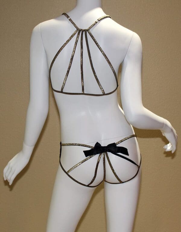 A mannequin wearing a black and gold lingerie.