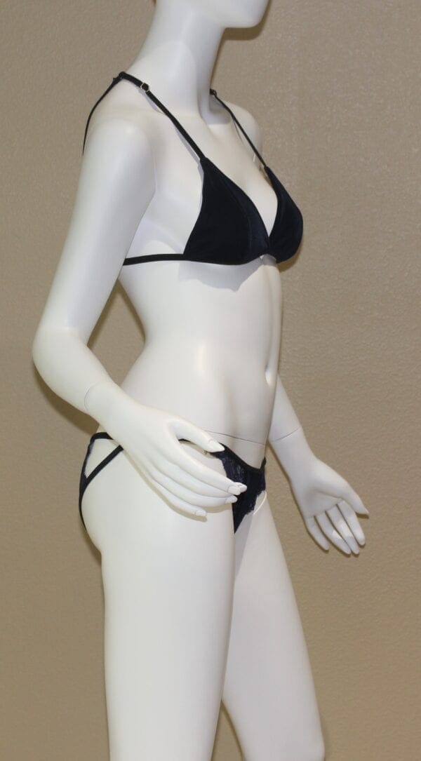 A woman in black and white bikini standing next to a mannequin.