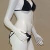 A woman in black and white bikini standing next to a mannequin.