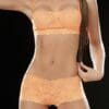 A woman in orange lingerie poses for the camera.