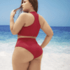 A woman in red bikini standing on the beach.