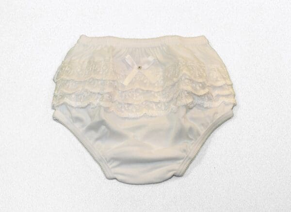 A white diaper with ruffles on it.