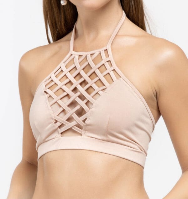 A woman wearing a beige top with a cage design.