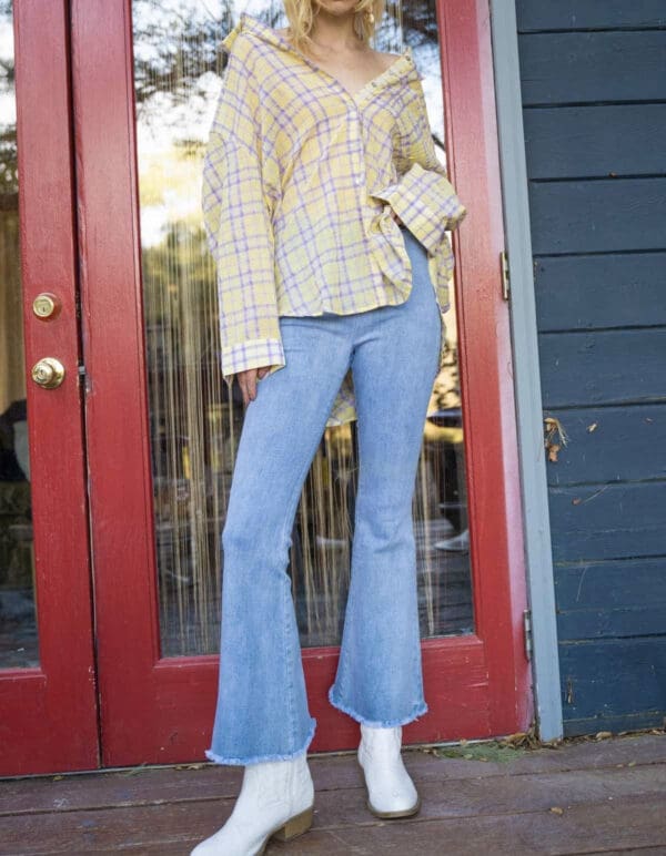 A woman standing in front of a red door.