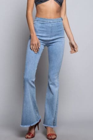 A woman wearing light blue jeans and a white top.