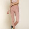 A woman in pink pants and top standing on one leg.