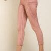 A woman wearing pink pants and white shoes.
