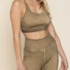 A woman wearing a tan sports bra and leggings.