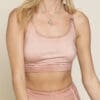 A woman wearing a pink sports bra and matching shorts.