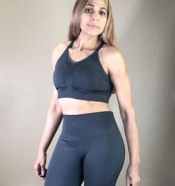 A woman in black sports bra and leggings.