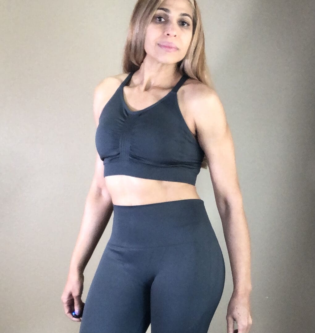 A woman in black sports bra and leggings.