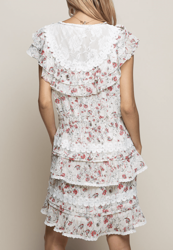 A woman wearing a floral dress with white lace.