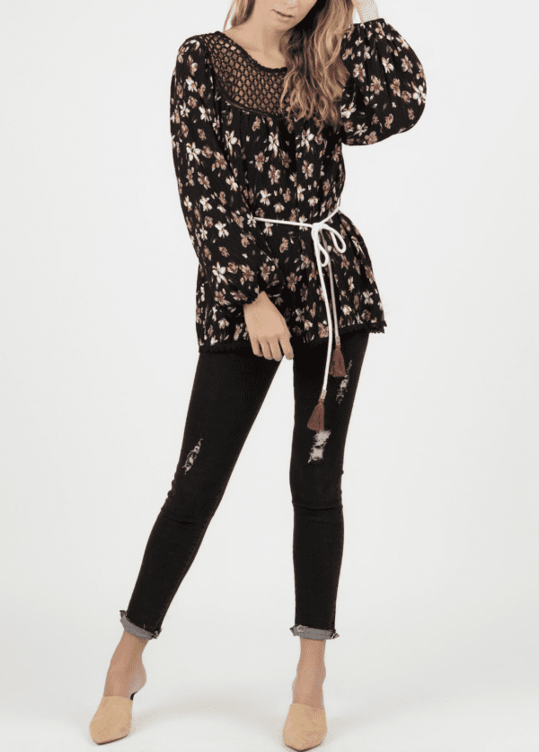 A woman in black jeans and floral shirt.