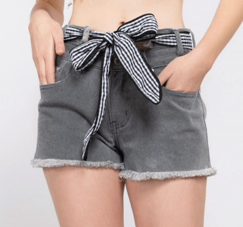 A woman wearing grey shorts with a bow.