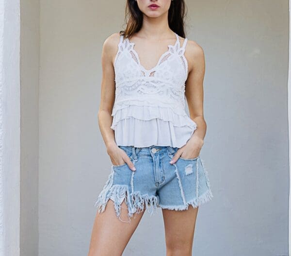 A woman in white top and blue shorts