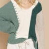 A woman wearing a green and white sweater.