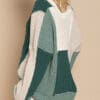 A woman wearing a green and white sweater.