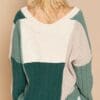 A woman wearing a sweater with green and white stripes.