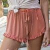 A close up of the waist and legs of a person wearing shorts.