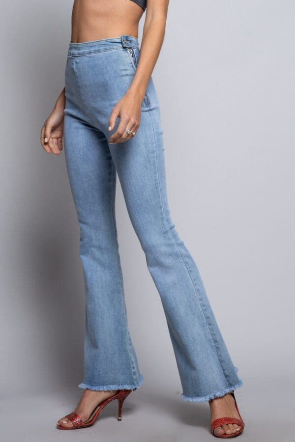 A woman wearing light blue jeans and high heels.