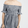 A woman wearing a dress with gingham pattern.