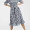 A woman in a dress is posing for the camera.