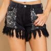 A woman wearing black shorts with sequins and fringes.