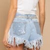 A woman wearing blue shorts with sequins and fringes.
