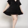 A woman in black dress posing for the camera.