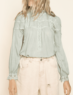 A woman wearing pink shorts and a green blouse.