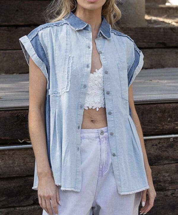 A woman wearing white shorts and a denim shirt.