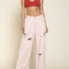 A woman wearing white jeans and red bra