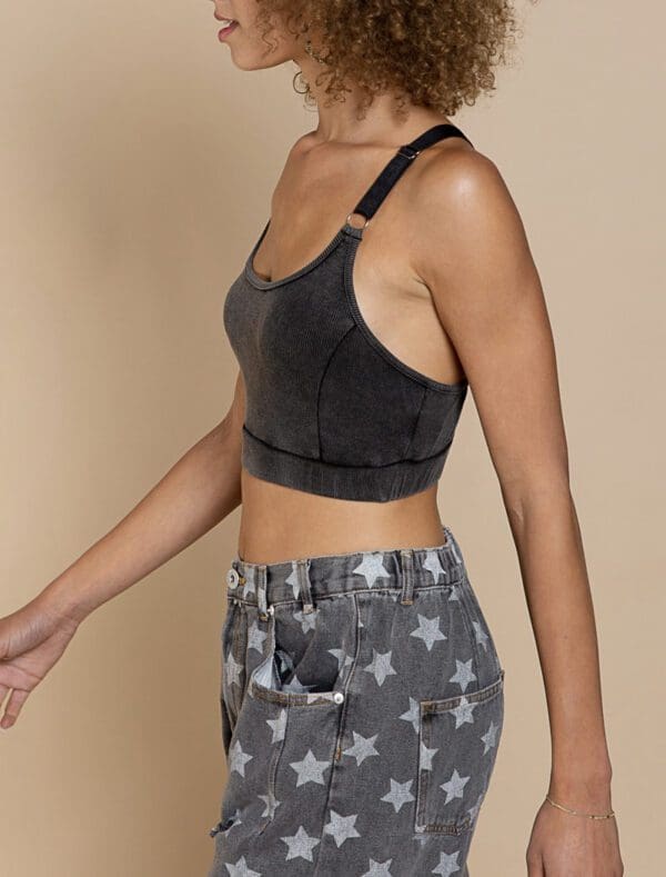 A woman in grey sports bra and star print shorts.