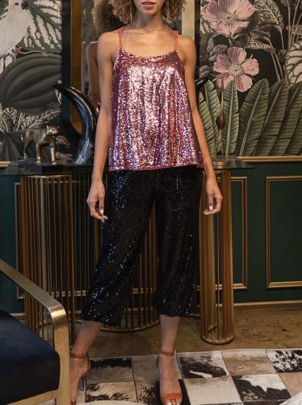 A woman in pink top and black pants standing on stairs.