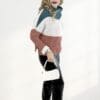 Woman in color-block sweater and boots.