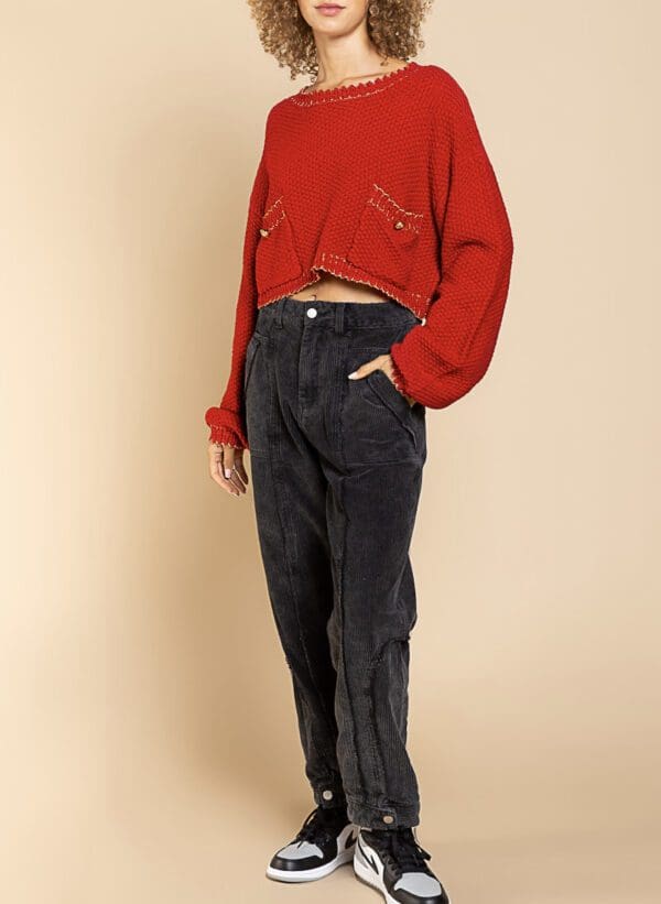 A person standing wearing jeans and a red shirt