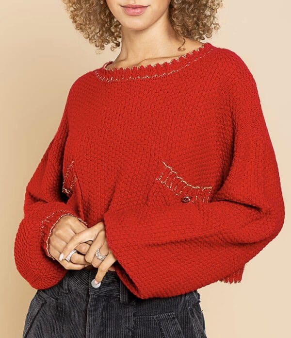 A woman in red sweater holding her arm.