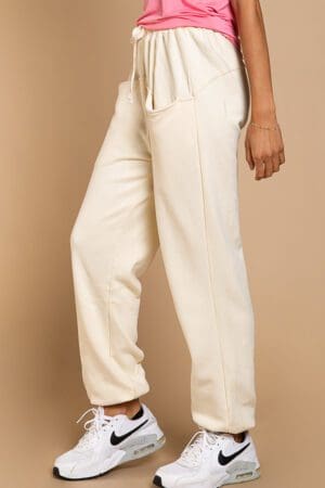 A woman wearing white pants and a black top.