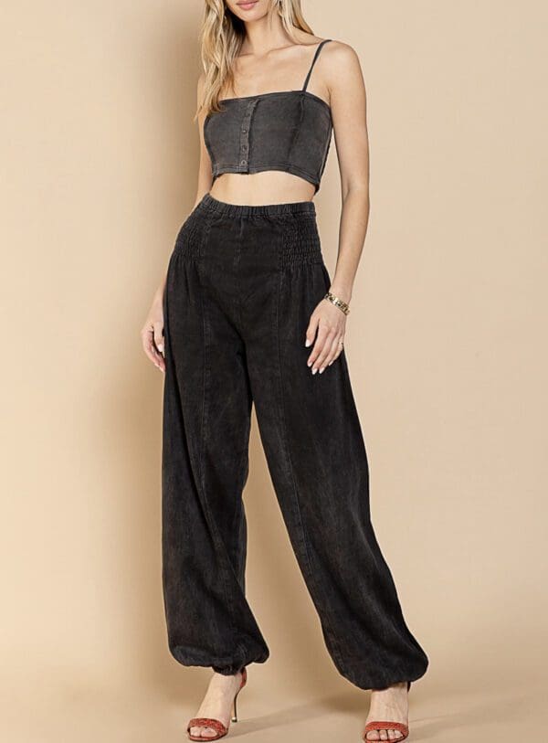 A woman in black pants and a crop top.