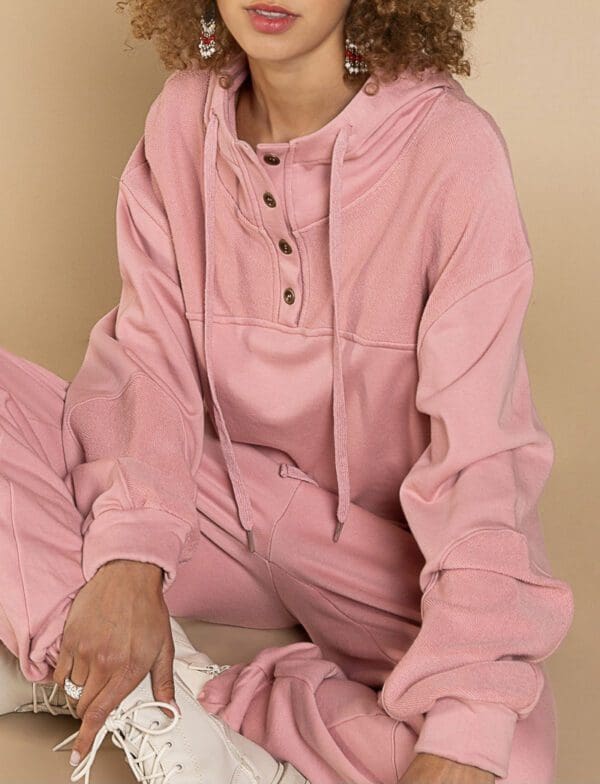 A person sitting on the ground wearing pink pajamas.