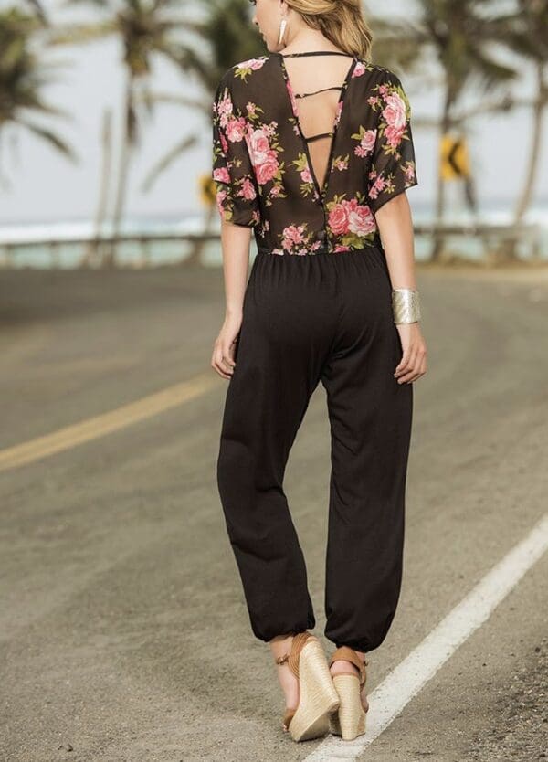 A woman in black pants and floral shirt.