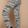 A woman wearing black and white zebra print pants.
