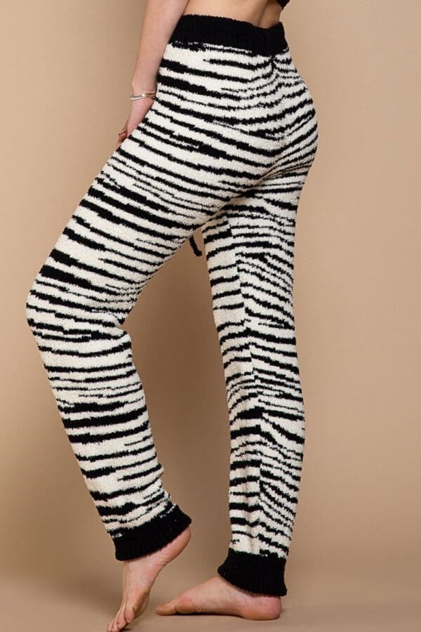 A woman wearing black and white zebra print pants.