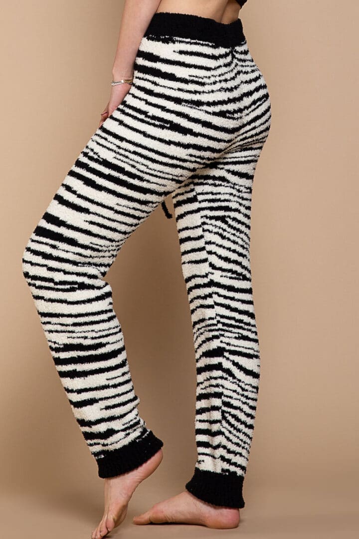 A woman wearing black and white zebra print pants.