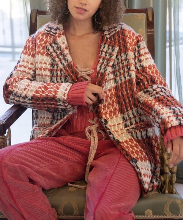 A woman sitting on top of a chair wearing a robe.