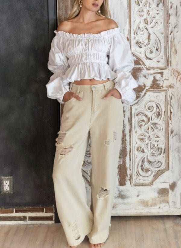 A woman in white shirt and beige pants.