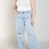 A woman wearing jeans and a white top.