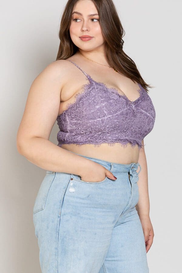 A woman wearing high waisted shorts and purple lace bra.