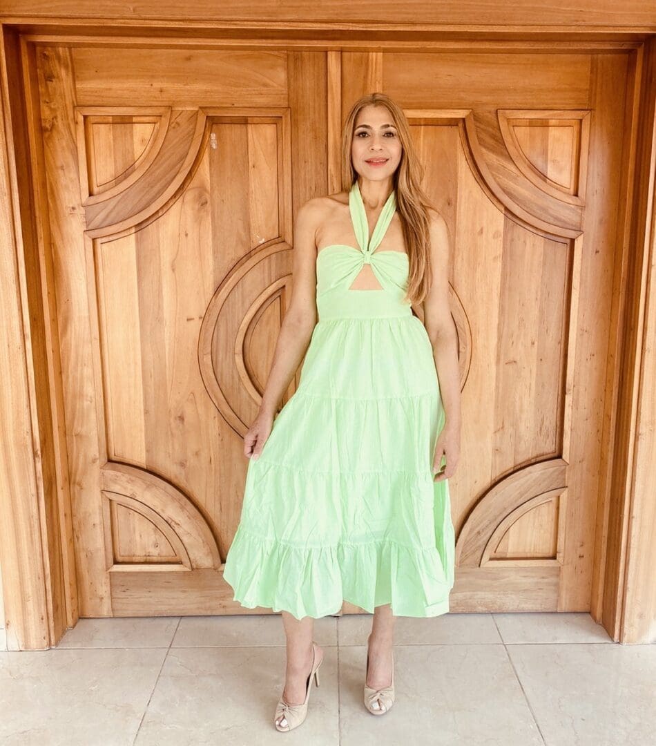 A woman standing in front of a wooden door.